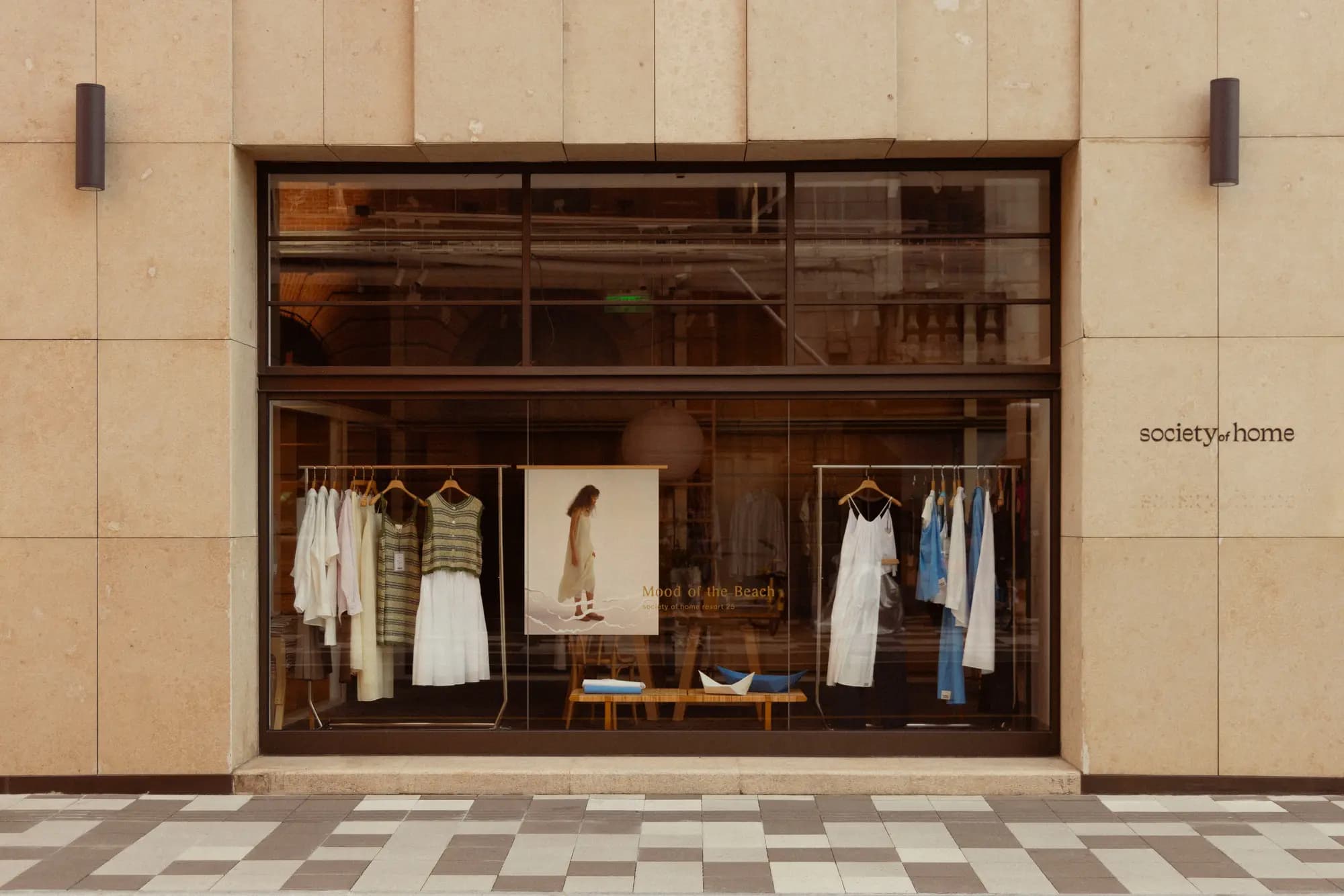 A boutique clothing store front with racks in the window