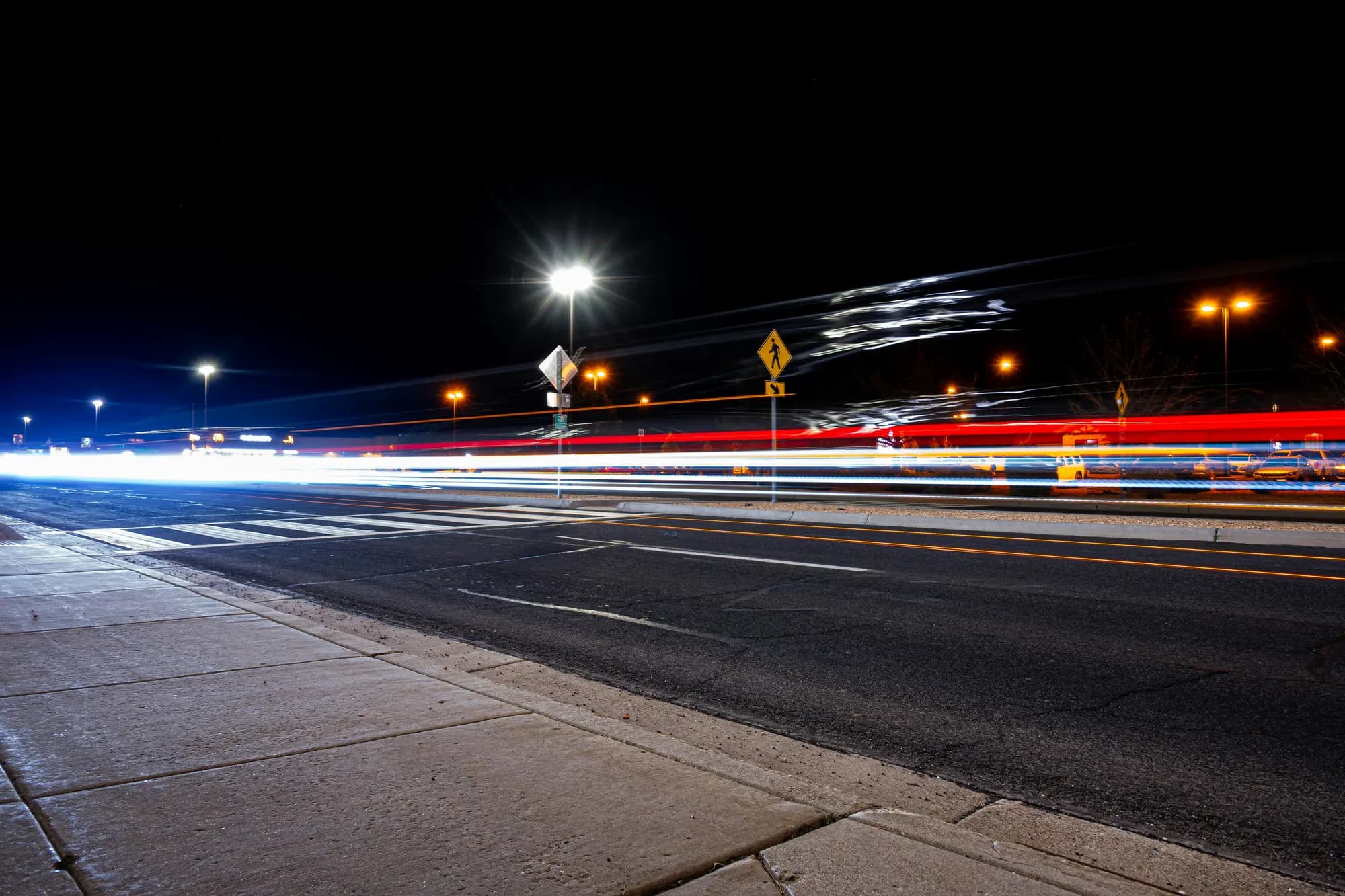 Long-exposure light trails along a night-time road