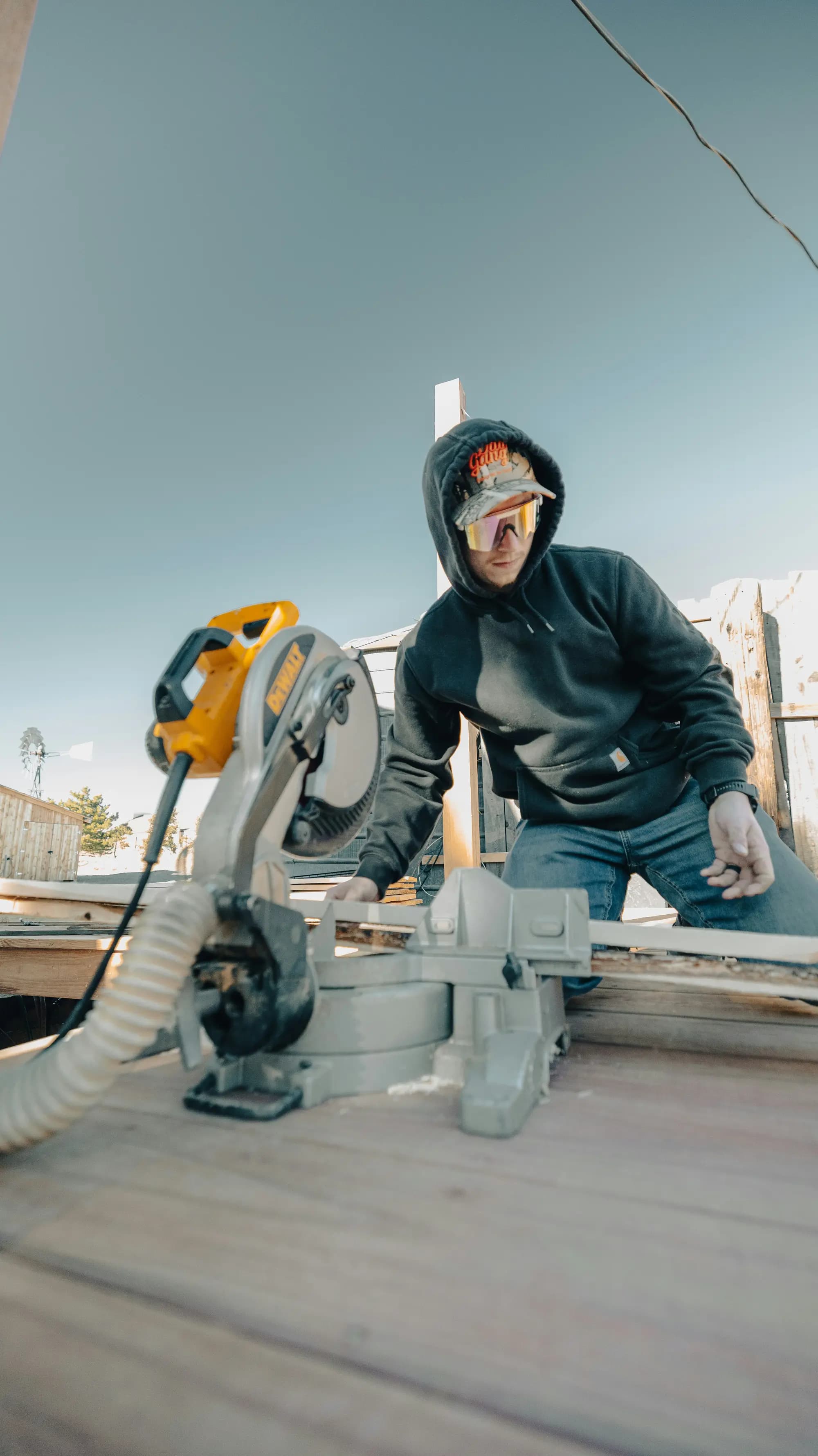 A tradesperson cutting timber with a mitre saw on site